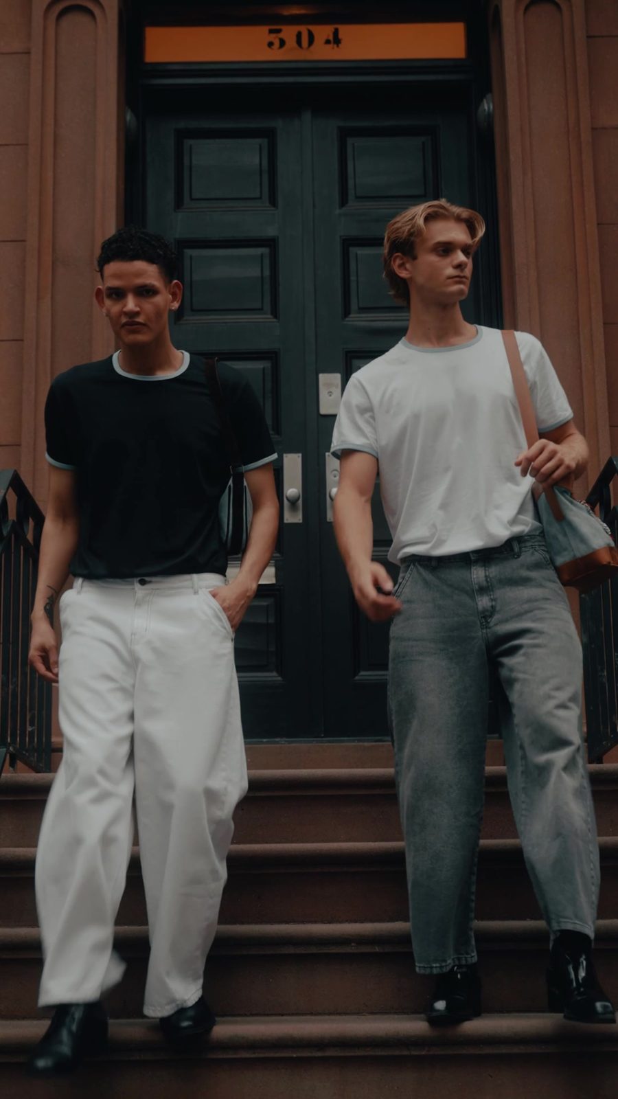 Dos chicos con remera negra y remera blanca con vivos de color