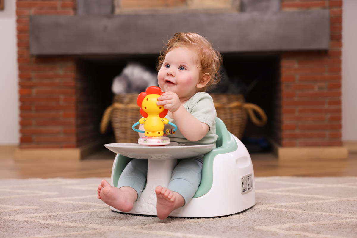 Bebê sentado no assento de apoio Bumbo