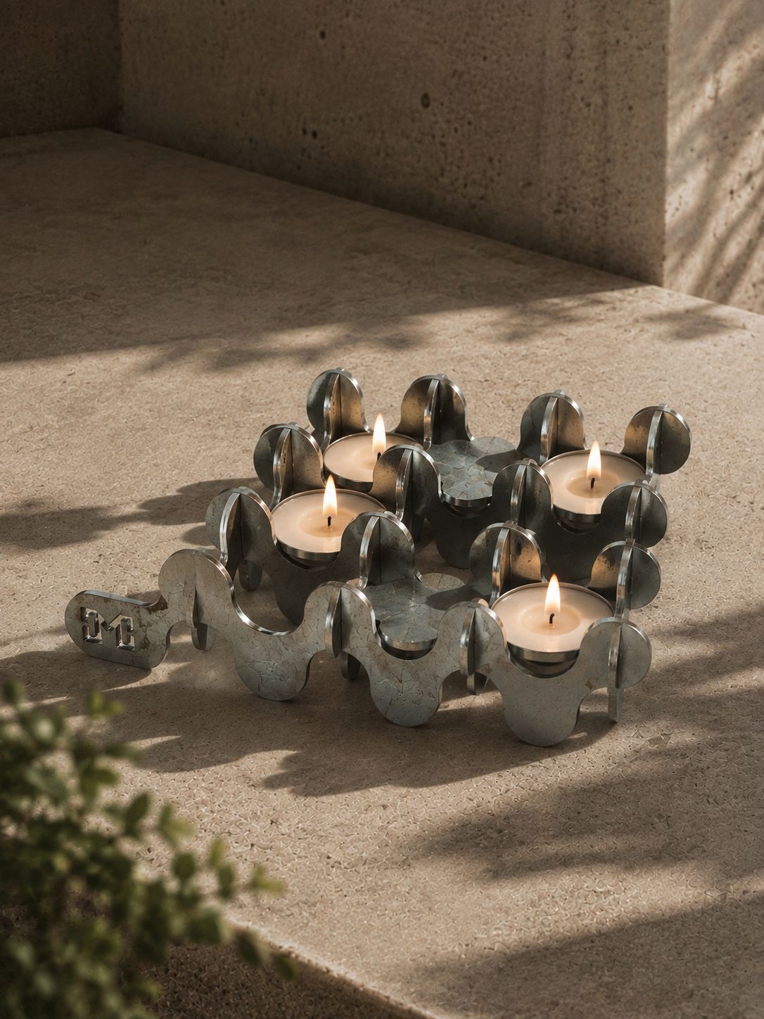 Onda, el portavelas de cuatro velas de noche, encendido sobre travertino