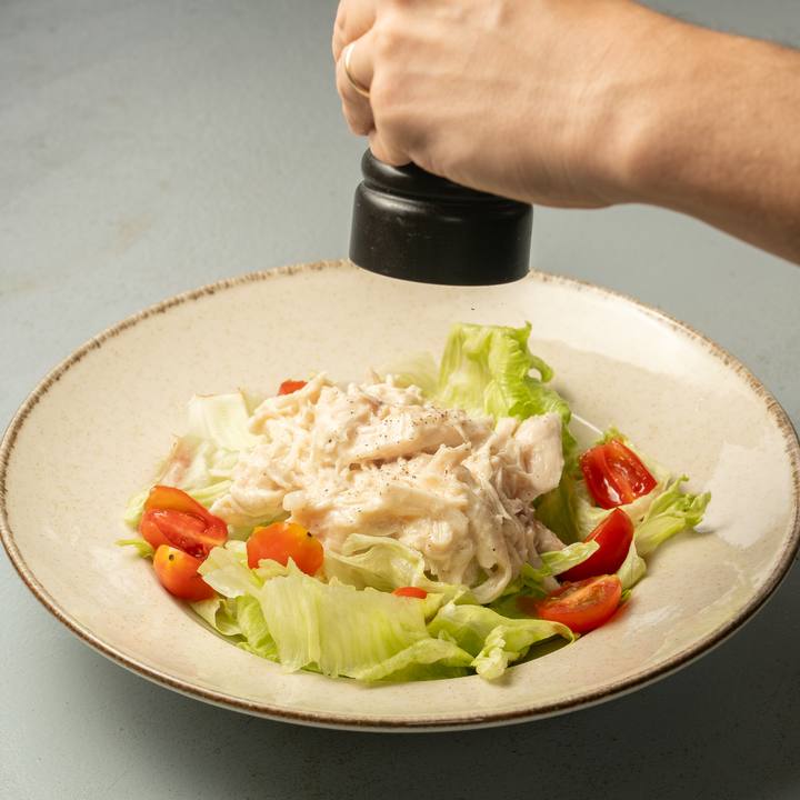 Pollo Caesar sobre ensalada fresca