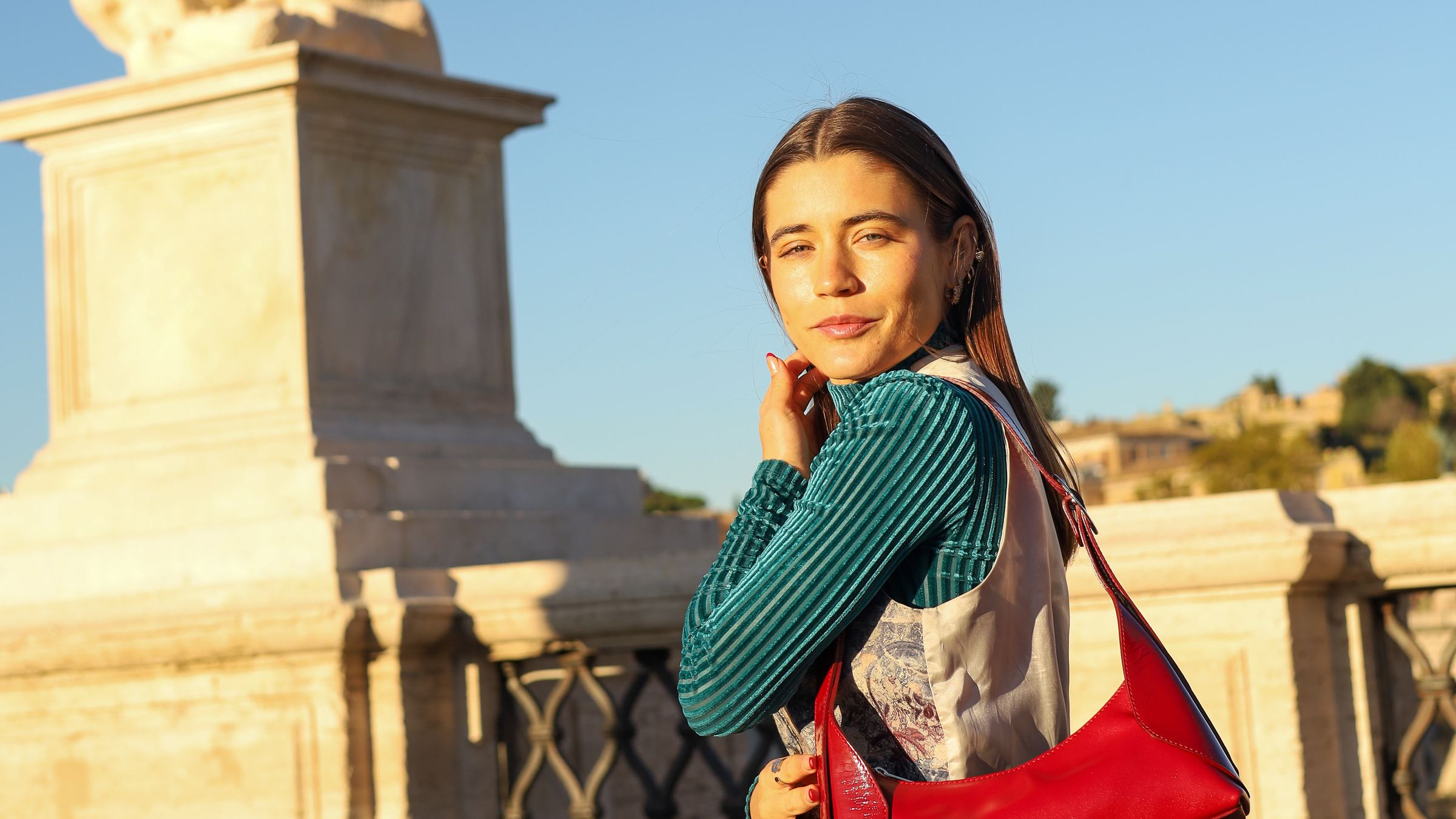 Mujer con la cartera Laia .01 roja en un puente de Roma