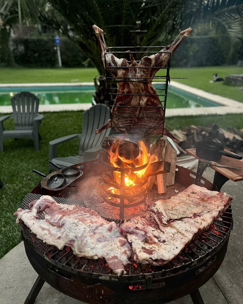 Cordero al asador junto a una pileta
