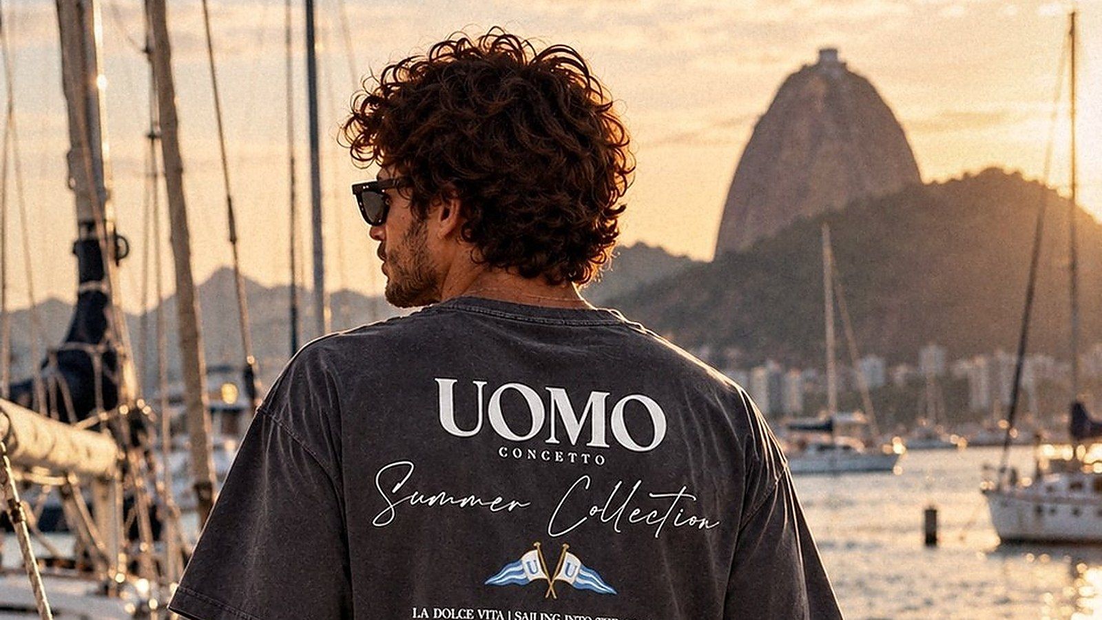 Modelo de costas no píer, com o Pão de Açúcar ao fundo, vestindo a camiseta Summer Collection chumbo estonado