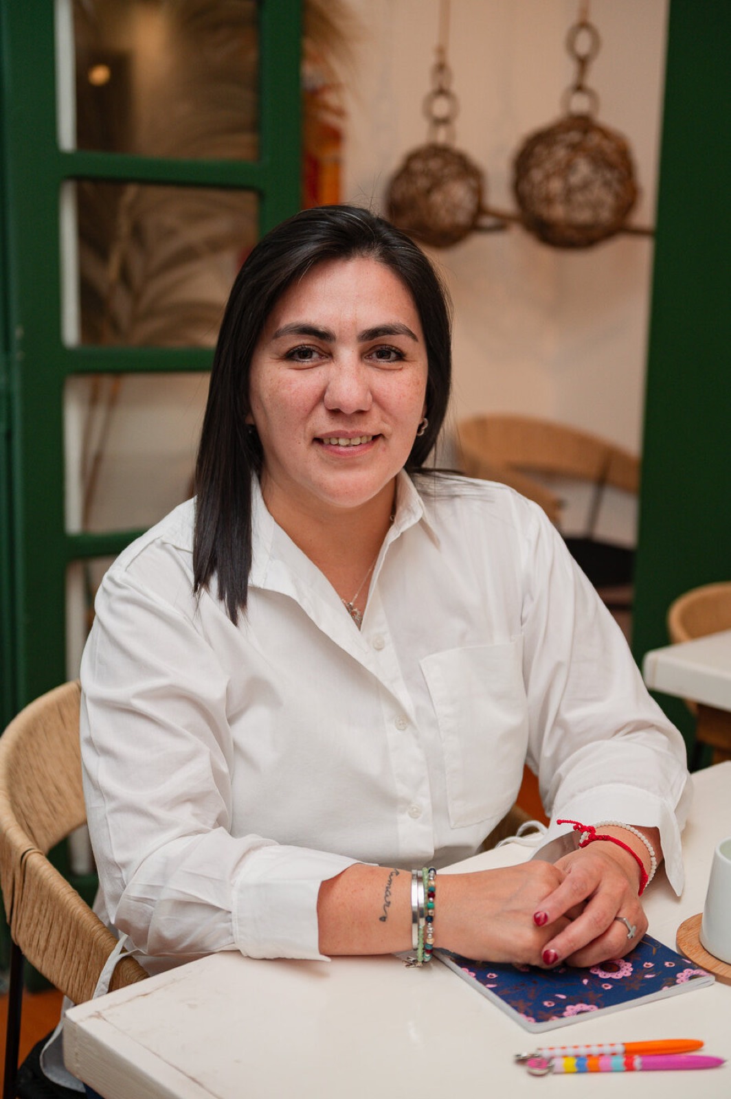Mariela Aguila con una taza, junto a su cuaderno.