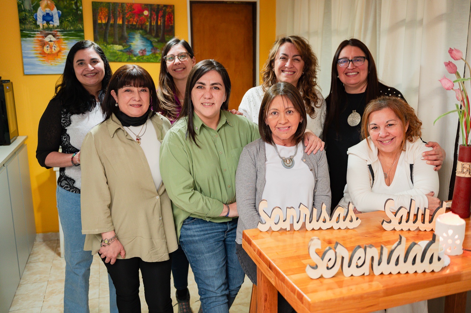 Grupo de mujeres compartiendo un encuentro del Método 3S, con un cartel de madera que dice Serenidad, Sonrisas y Salud.
