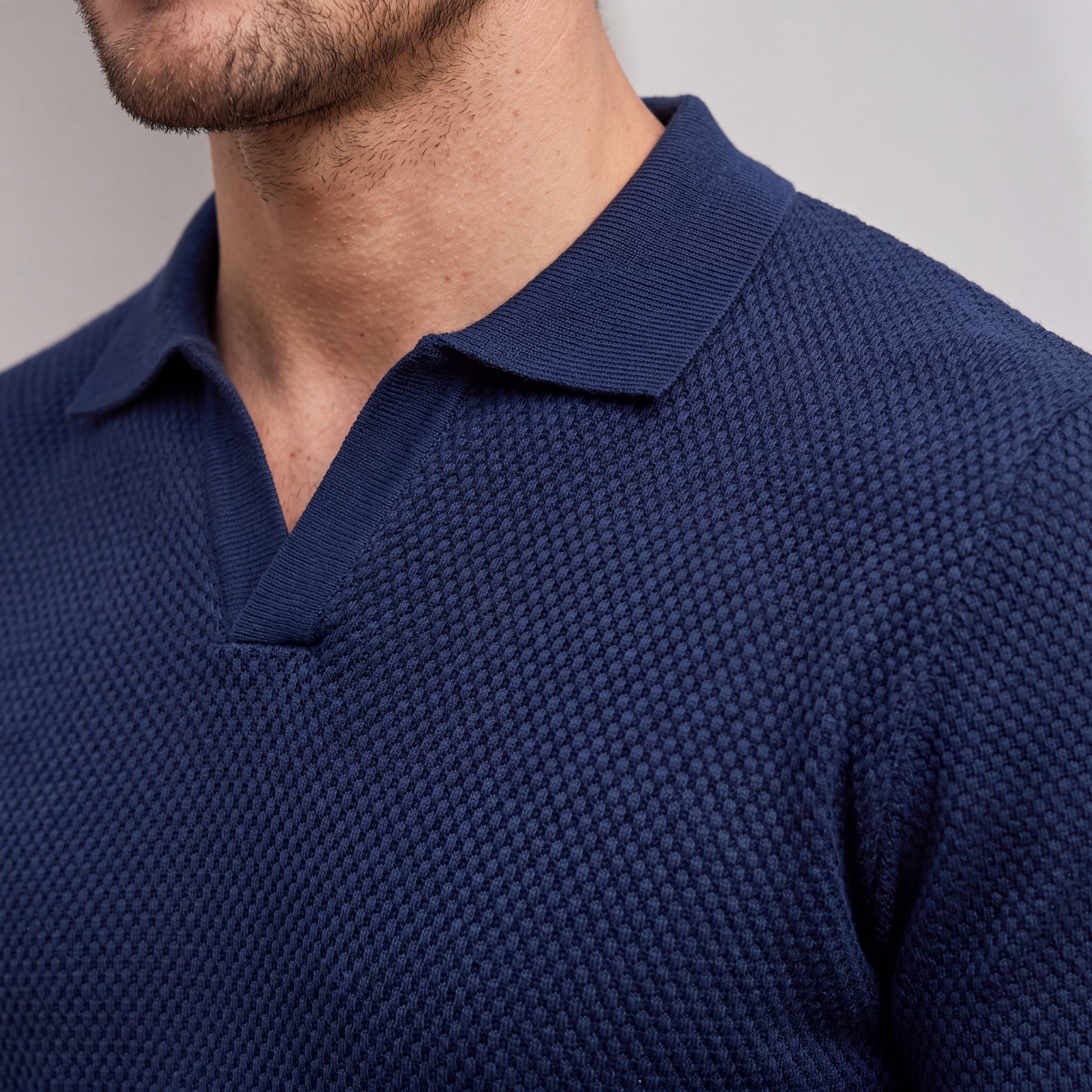 Detalle del cuello V del polo tejido