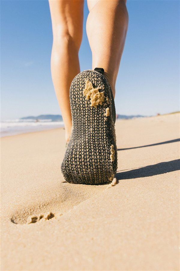 Tênis Aldea Guarion caminhando na areia da praia