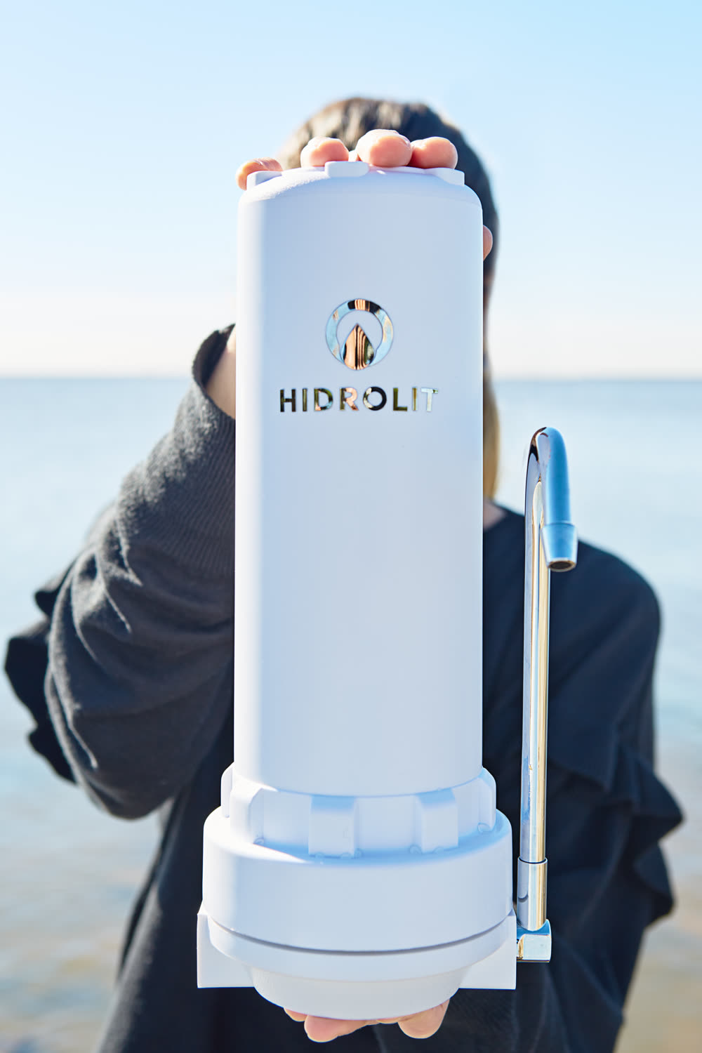 Una mano sirviendo agua del purificador