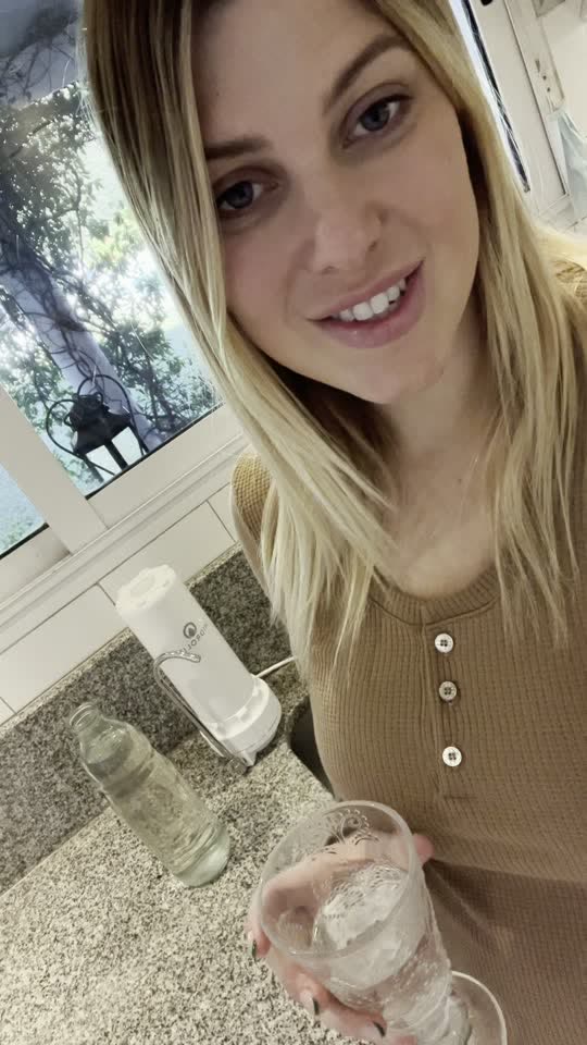 Una clienta con un vaso de agua junto al Clorine Off en su cocina