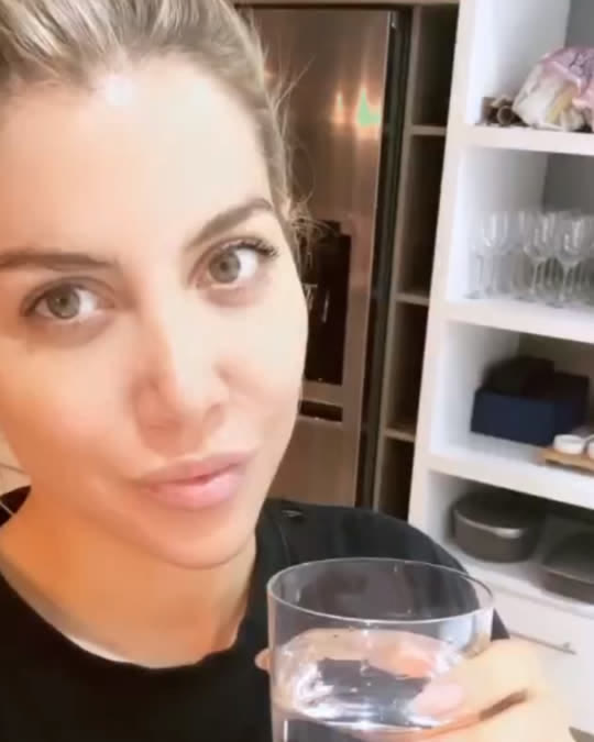 Una clienta con un vaso de agua en su cocina