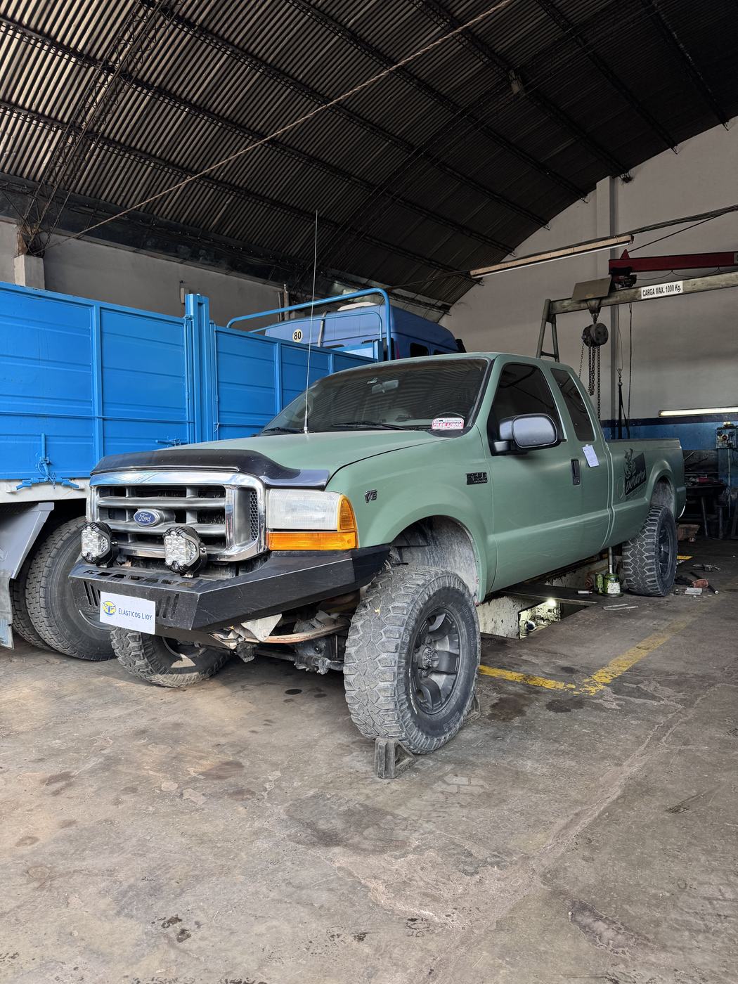 Camioneta en reparación de elásticos, elevada en el taller