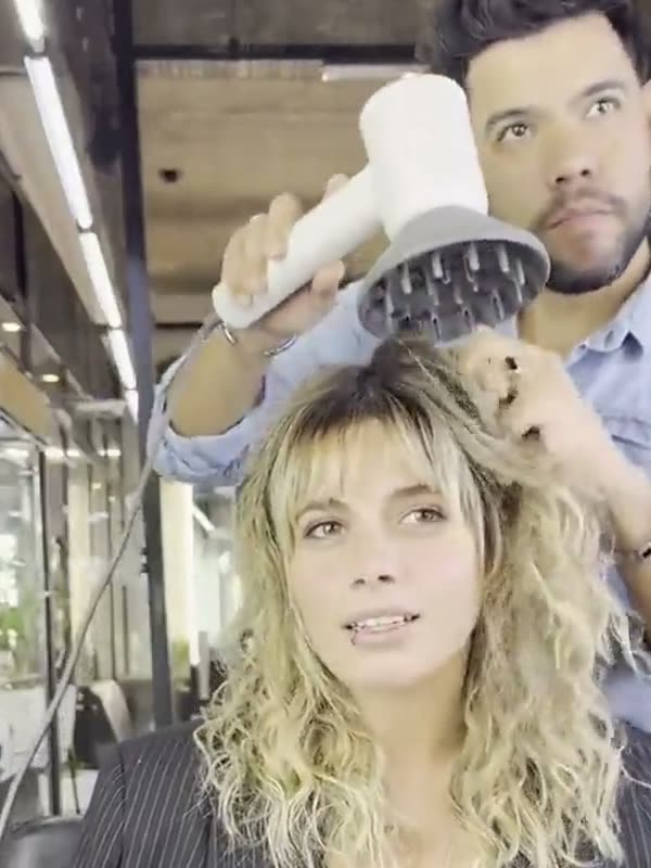 El peluquero secando los rulos de una clienta con el difusor del HD2000, en su salón