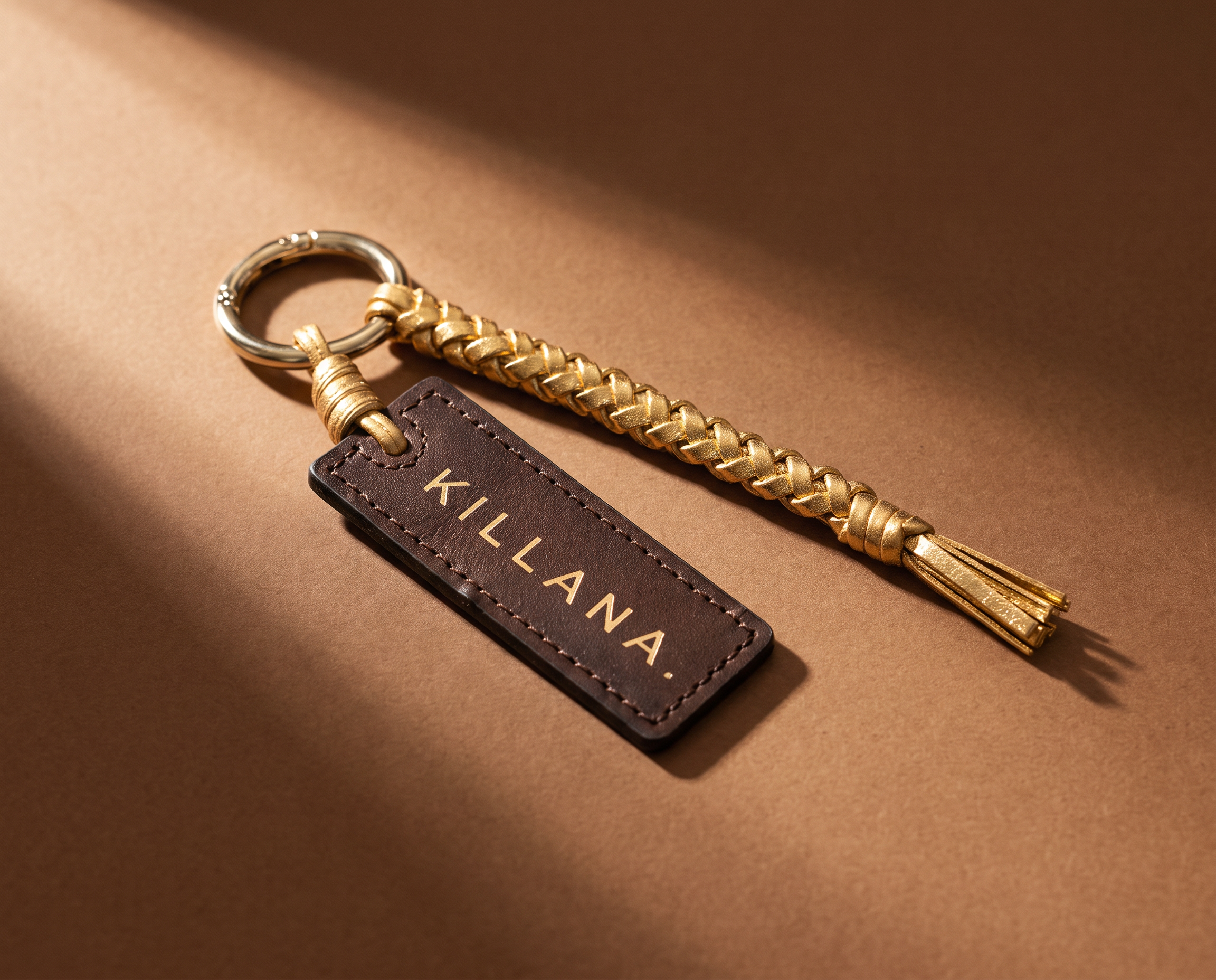 Charm da edição Relicário: tag em couro Killana e trança dourada com argola