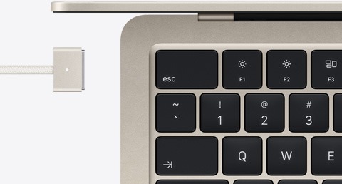 Detalhe do teclado e do cabo MagSafe do MacBook Air estelar, na mesma cor