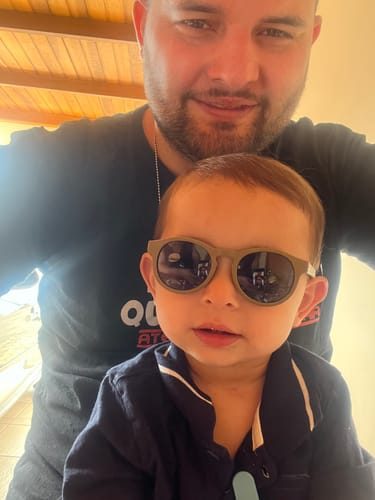 Pai e beb&ecirc; usando &oacute;culos SunKids