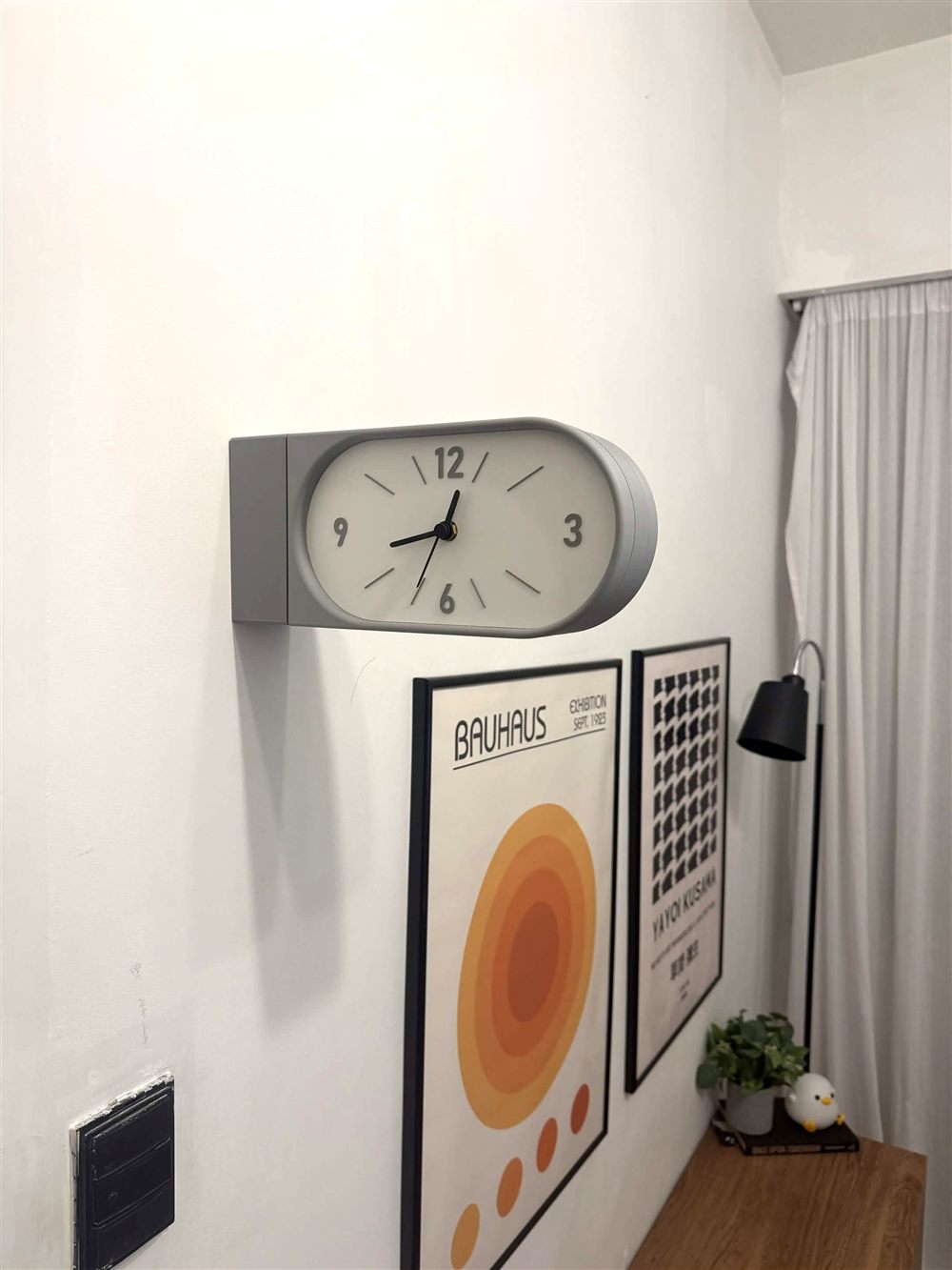 Reloj Doble Kansei gris instalado en ambiente con cuadros