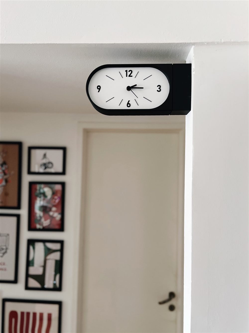 Reloj Doble Kansei negro instalado en ambiente con cuadros