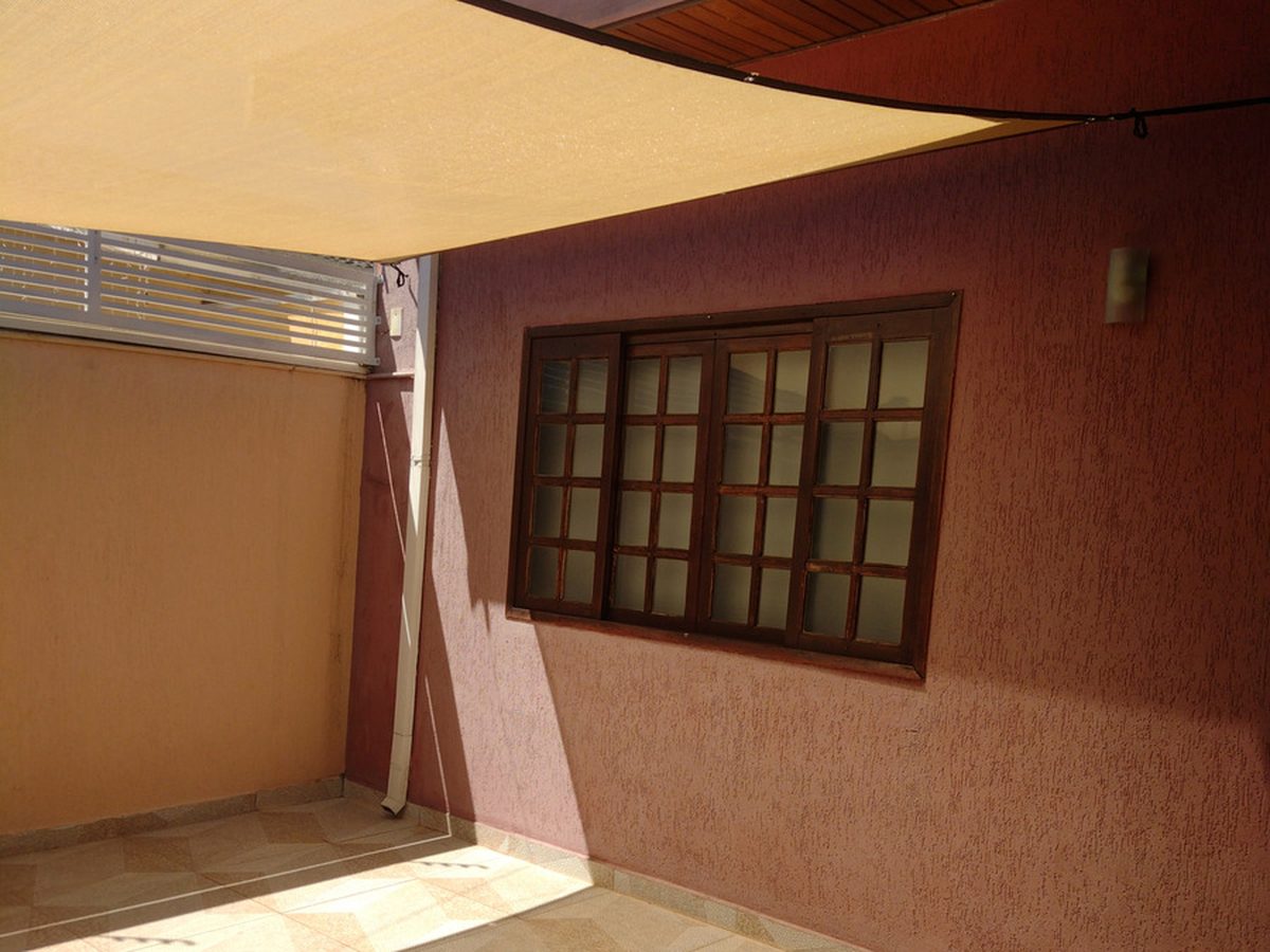 Solaraia · vela sobre patio residencial com parede texturizada · identidade preservada