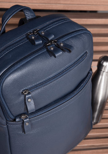 Mochila Bennemann em couro azul com destaque para zíperes e bolso frontal.