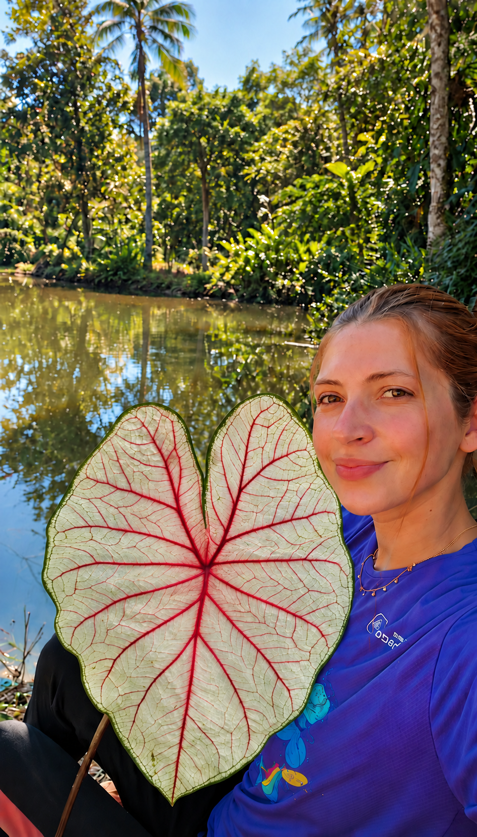Fundadora do Mudário do Vale segurando uma folha de Caladium junto à natureza