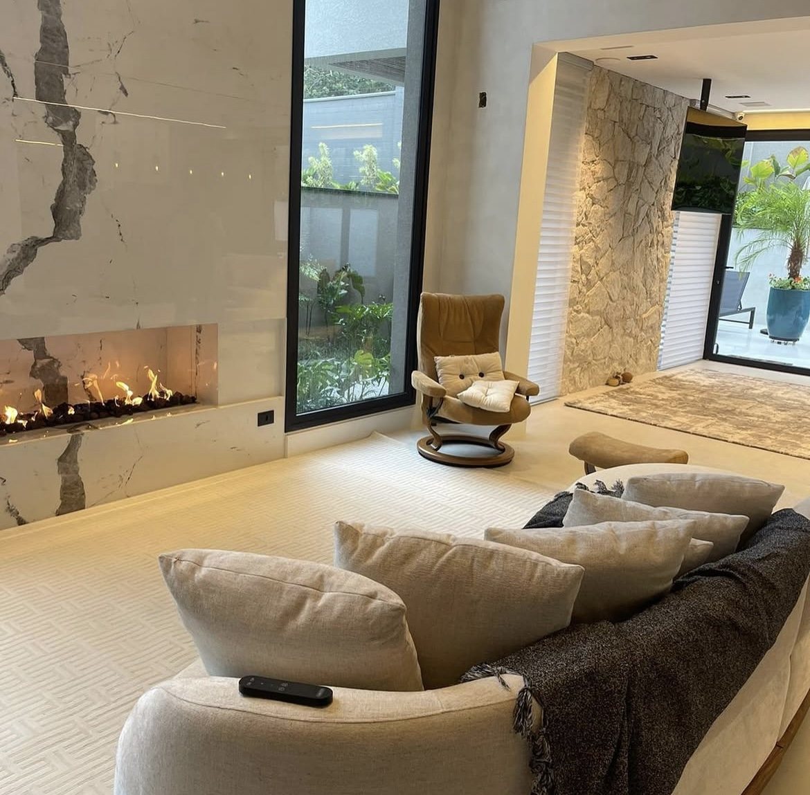 Ambiente integrado com tapetes diferentes na sala de estar e na sala de TV