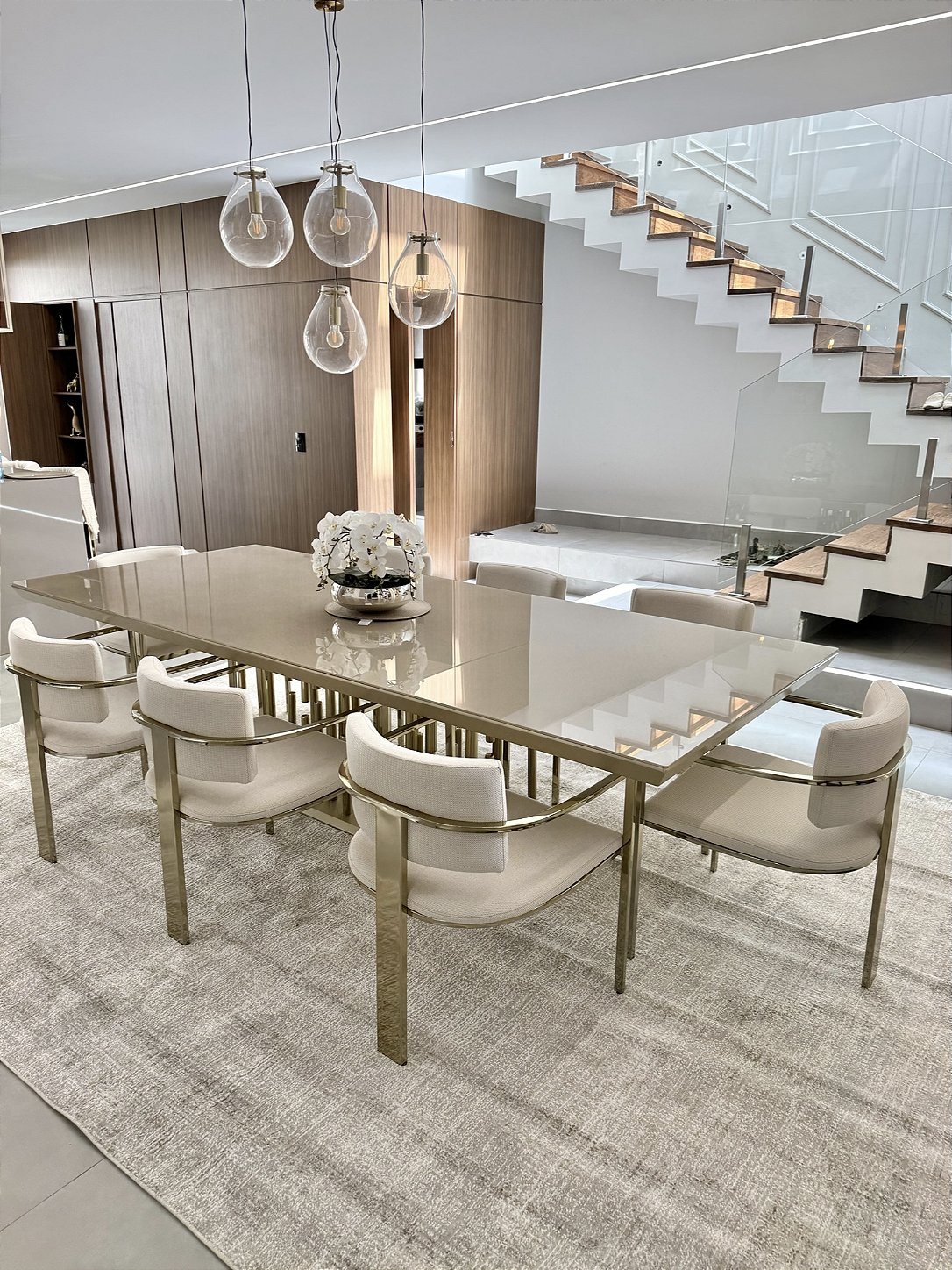 Sala de jantar com cadeiras afastadas ainda sobre o tapete