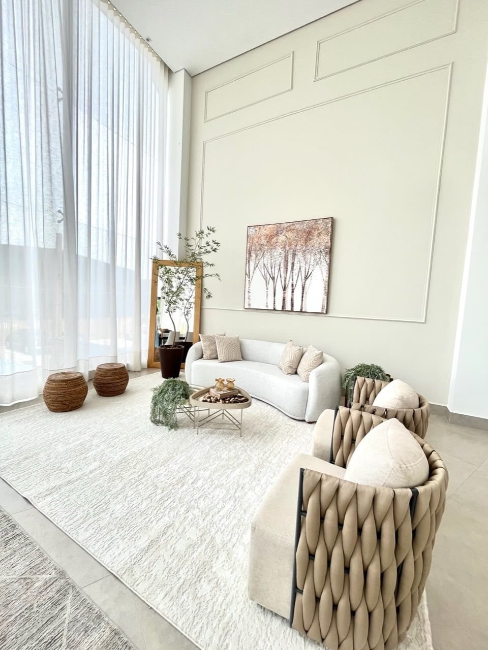Sala de estar com tapete grande integrando sofá e poltronas