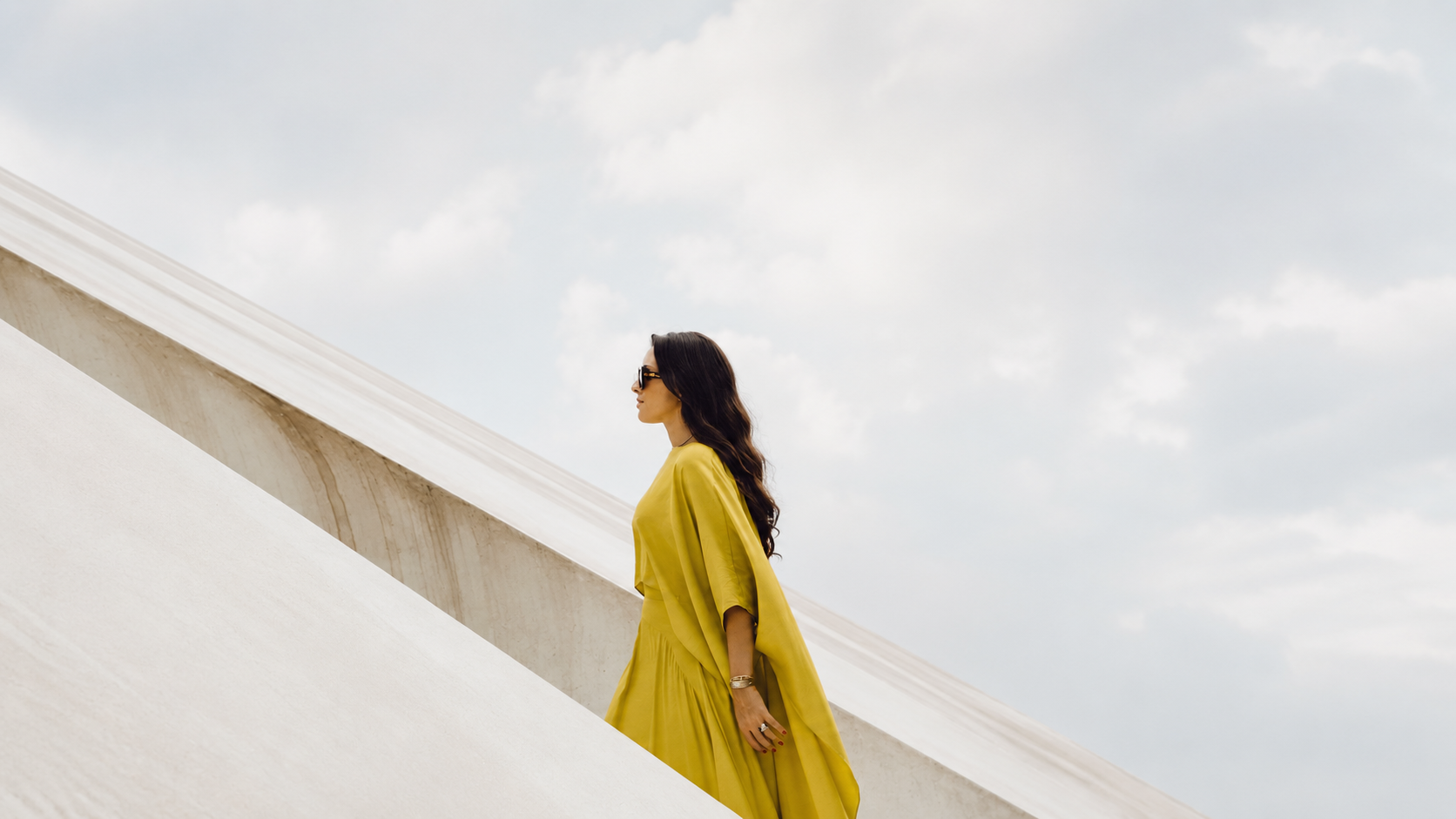 Bia Souza em vestido verde em cenário arquitetônico